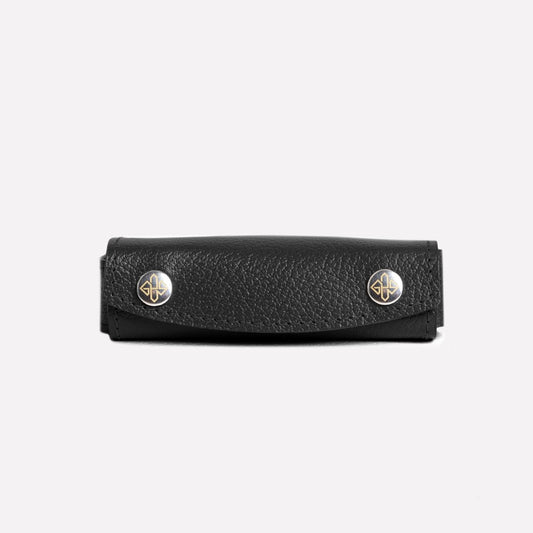Black leather case with gold accents on a white background