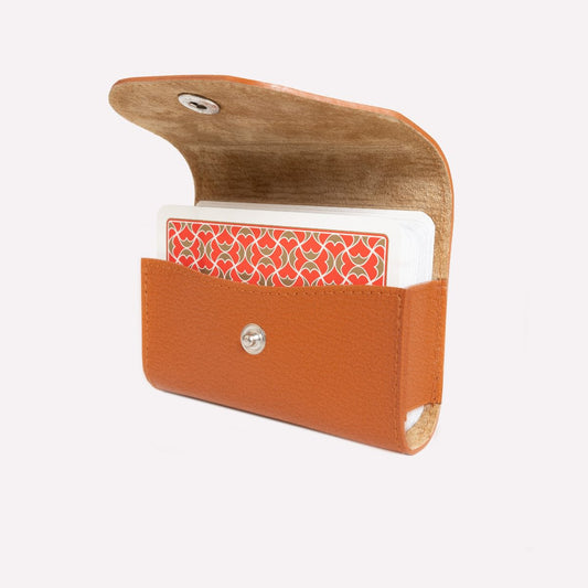 Brown leather cardholder with a white card featuring a red pattern on a white background