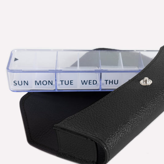 Weekly pill organizer with black carrying case on a white background