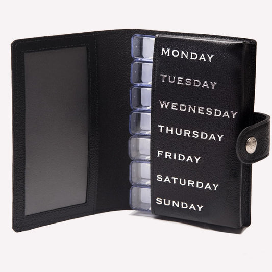 Black pill organizer with days of the week labels on a white background