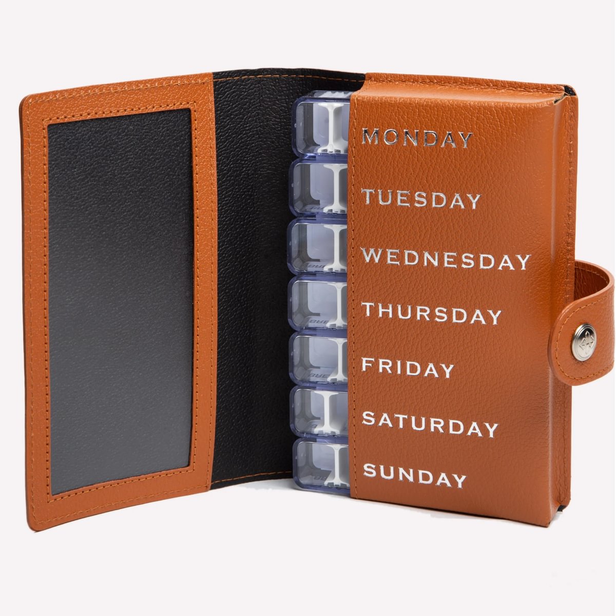 Weekly pill organizer with brown leather casing and black interior on a white background