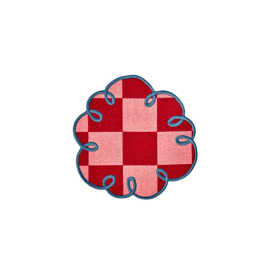 Red and pink checkered cloth with blue embroidery on a white background
