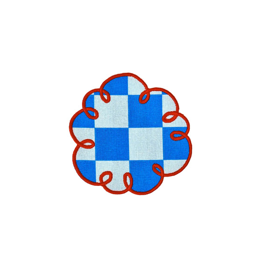 A circular patch featuring a blue and white checkered pattern with a red stitched border and red looped details along the outer edge, shown on a plain white background.