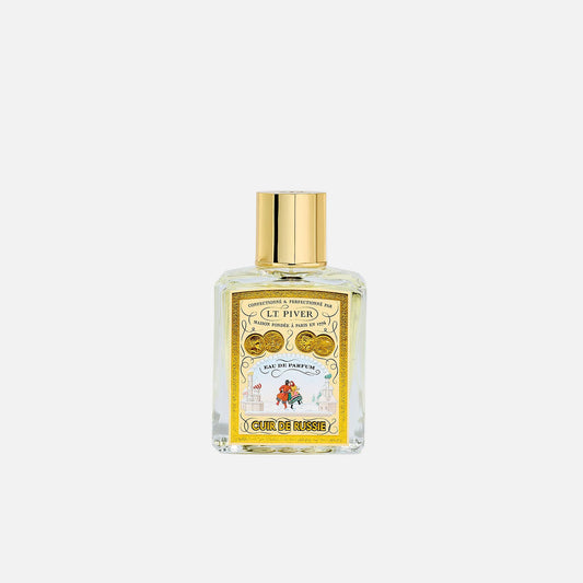 Perfume bottle with gold cap on a light gray background