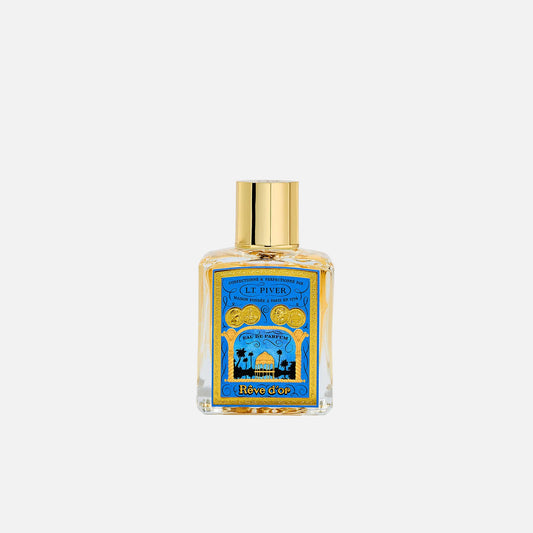 Perfume bottle with gold cap on a light gray background