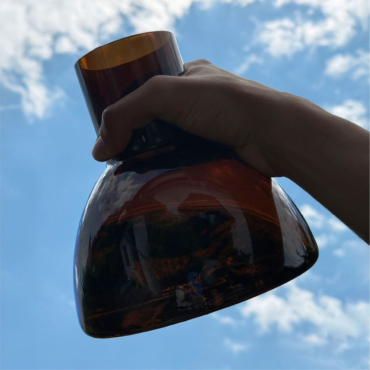 PLASH Carafe in Brown held against the sky