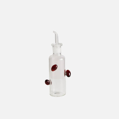 Clear glass bottle with red berries on a white background