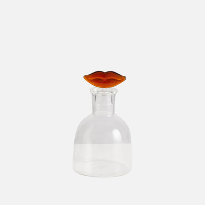 Clear glass decanter with a amber-colored stopper on a white background