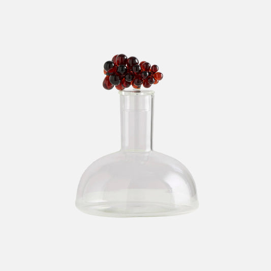 Clear glass vase with a decorative red and black bead top on a white background