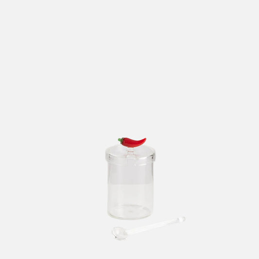 Clear glass pepper grinder with a red pepper on a white background