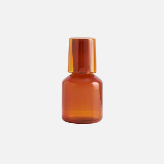 Amber glass bottle on a light gray background