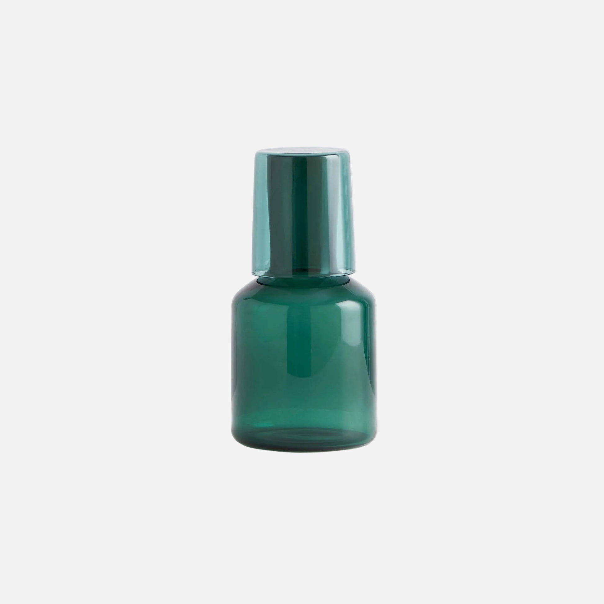 Green glass bottle with a metallic cap on a light gray background
