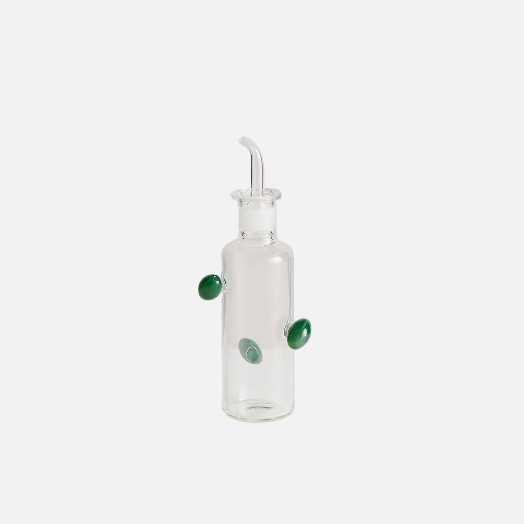 Glass carafe with green stones on a white background