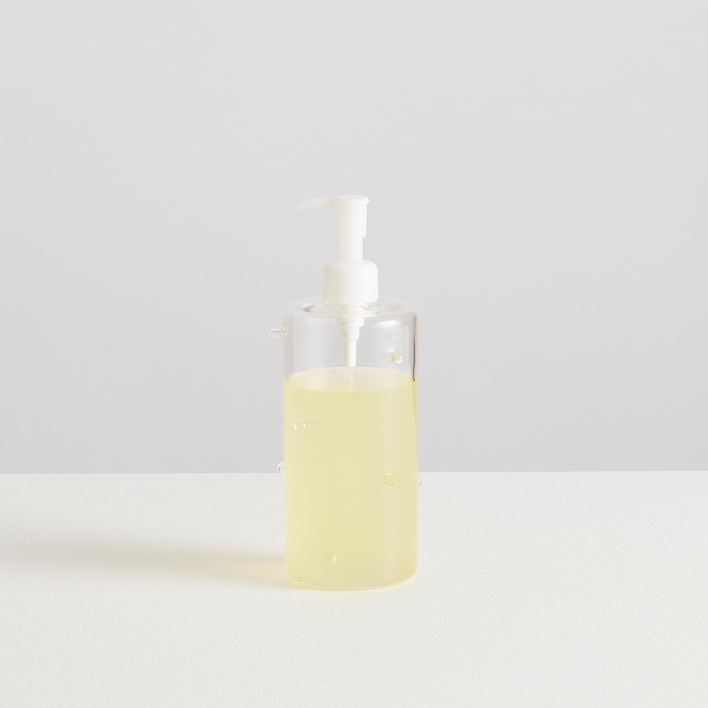 Clear bottle with a white pump dispenser on a light gray background