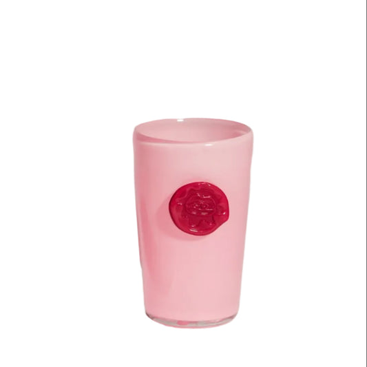 Two ceramic tumblers, one white and one pink, with circular designs on a gray background.