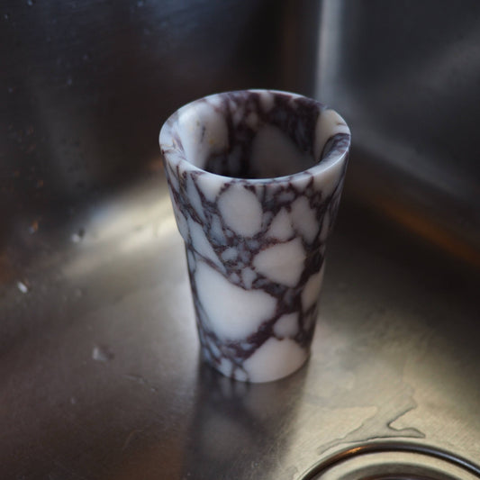 Marble-patterned ceramic cup on a metallic surface