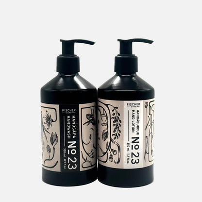 Two black bottles of Fischer Handzeugurum No 23 hand wash and lotion on a white background