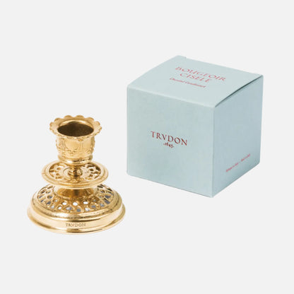 Decorative gold candle holder next to a light blue box with 'TRYDON' branding on a white background