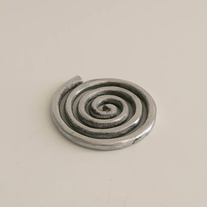 Metallic spiral object on a beige background