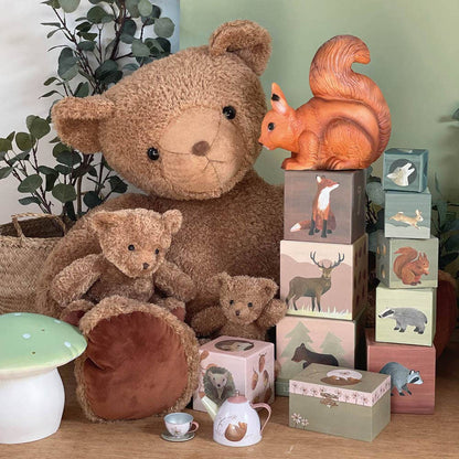 Collection of teddy bears and wooden blocks with animal designs on a wooden surface.