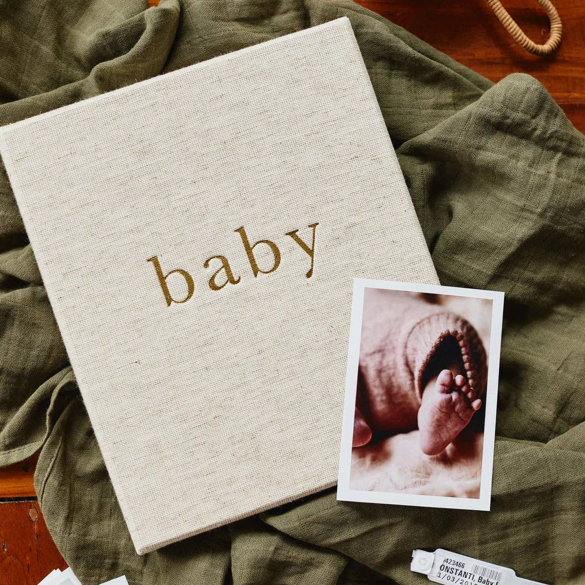 Album with 'baby' text and a photo of a baby's foot on a green blanket.