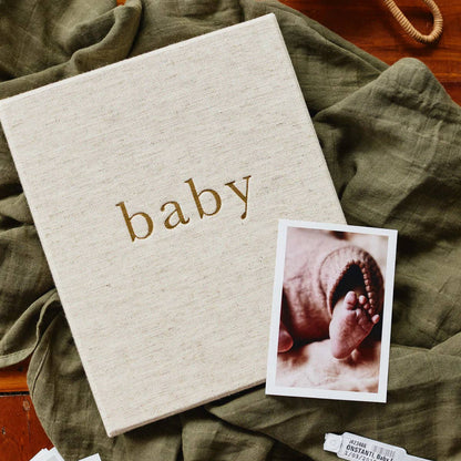 Album with 'baby' text and a photo of a baby's foot on a green blanket.