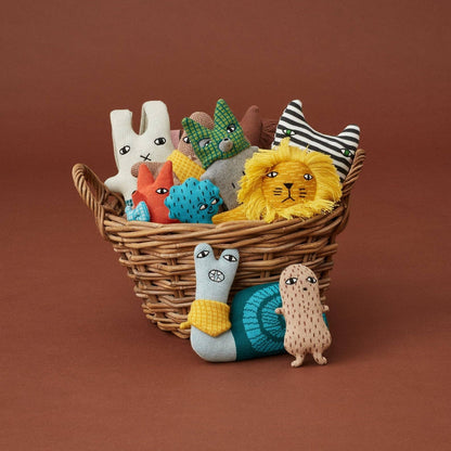 Wicker basket filled with colorful soft toys on a brown background