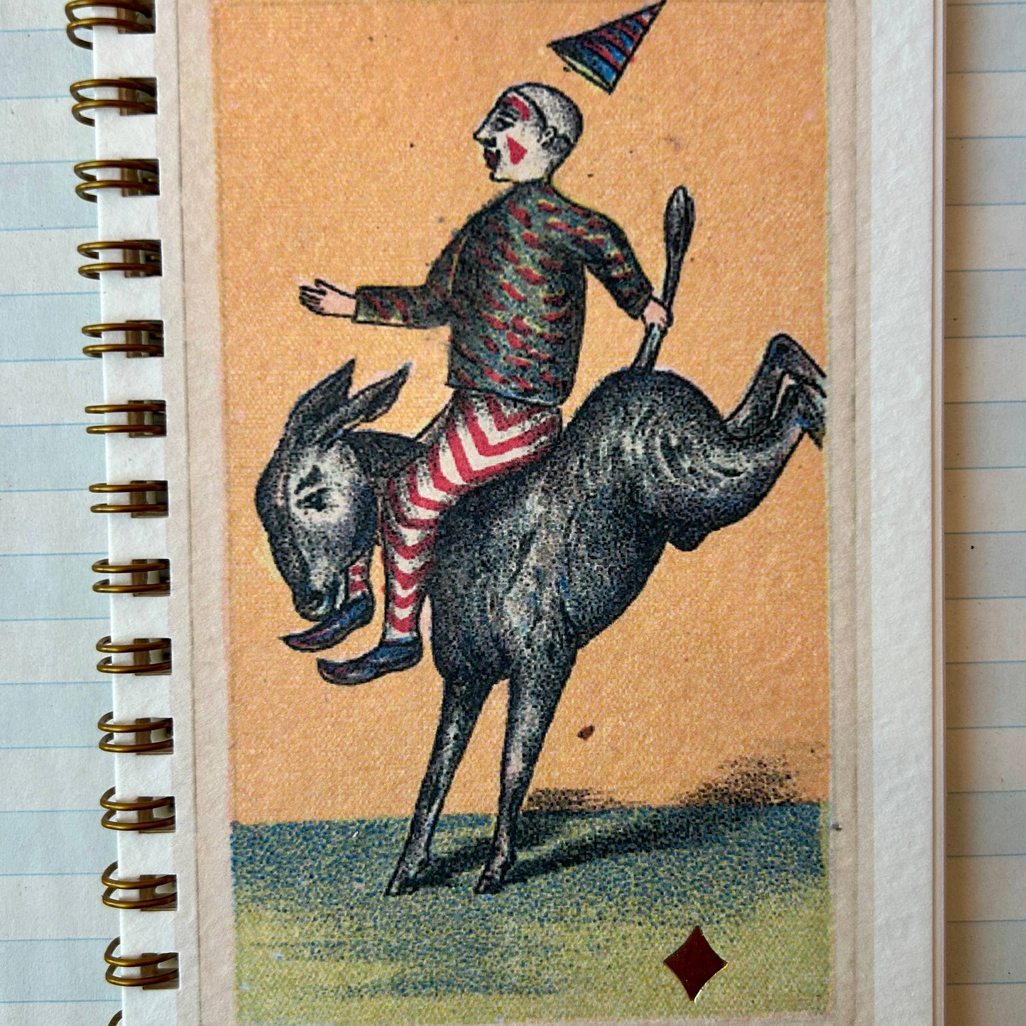 Notebook with a vintage-style illustration of a clown riding a donkey on the cover.