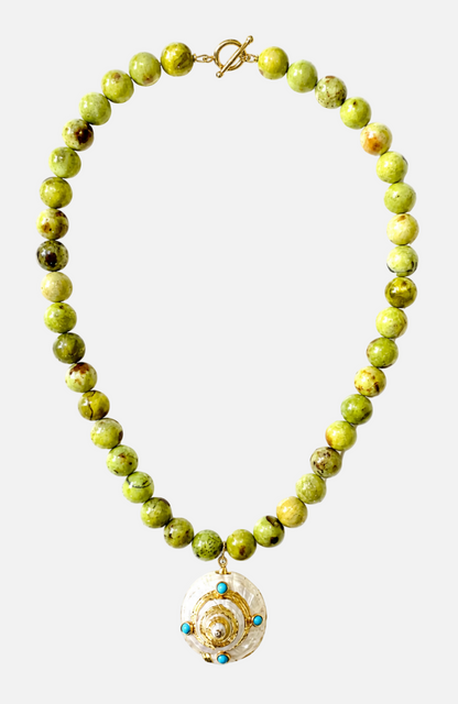 Green beaded necklace with a gold and turquoise pendant on a white background