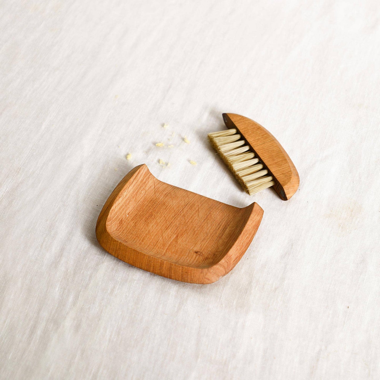 Wooden hairbrush with open case on a light wooden surface