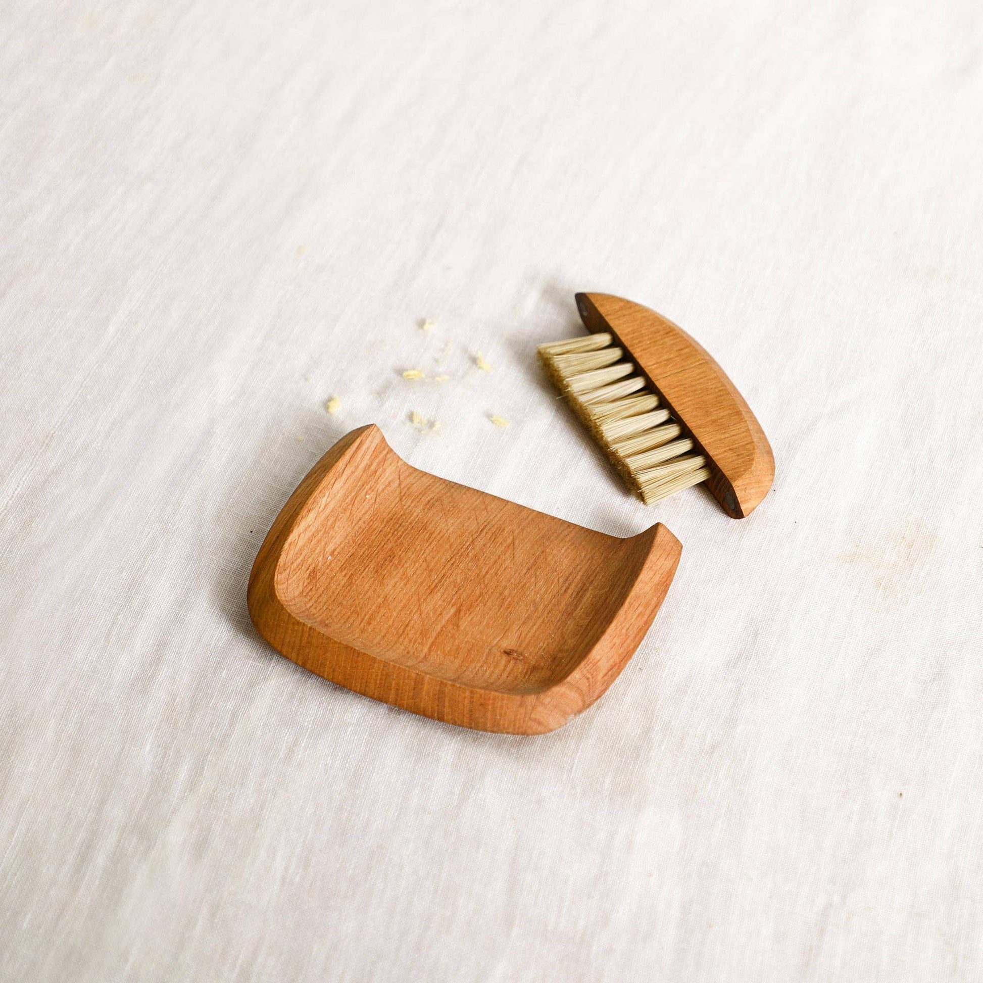 Wooden hairbrush with open case on a light wooden surface