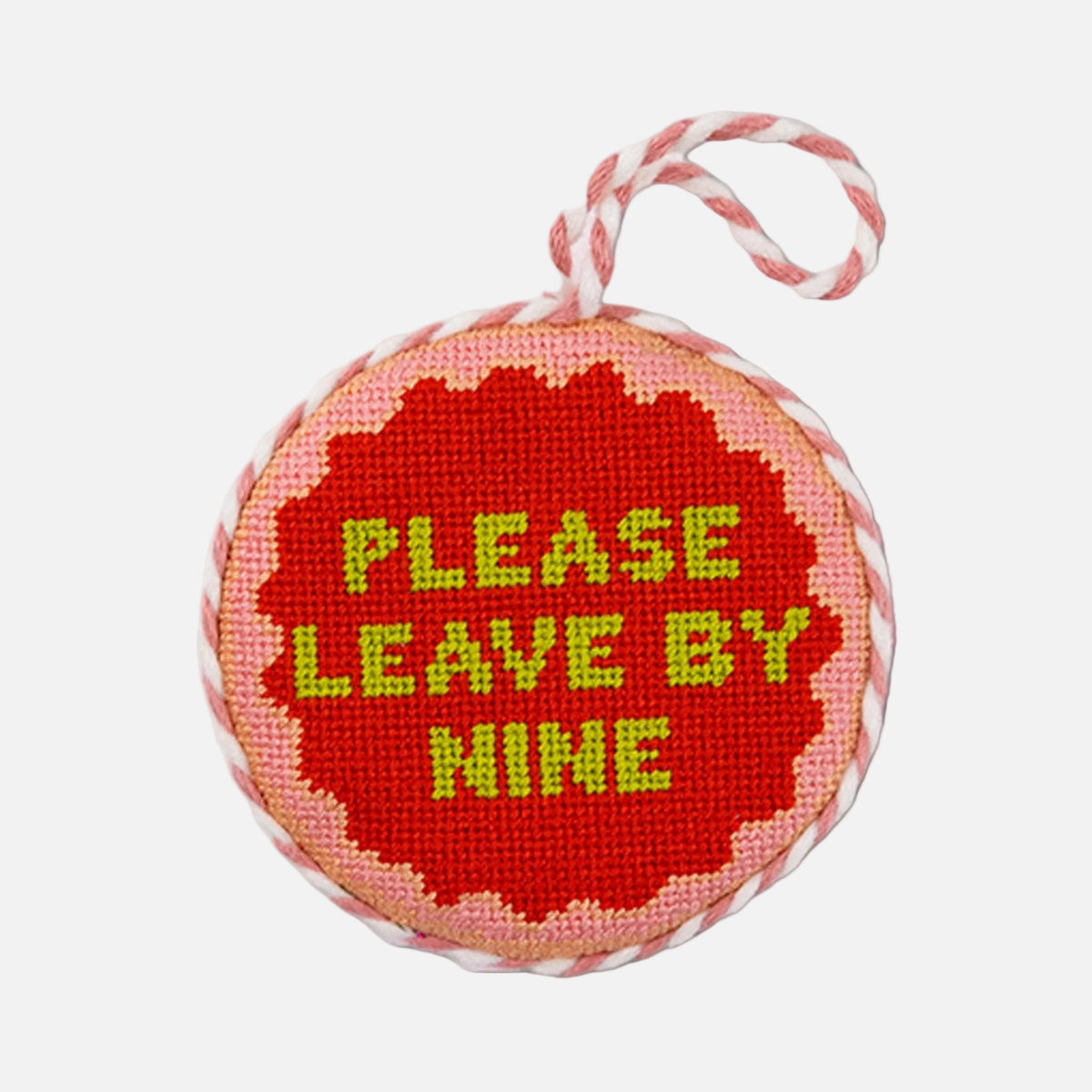 Round needlepoint ornament with 'Please Leave by Nine' text on a white background