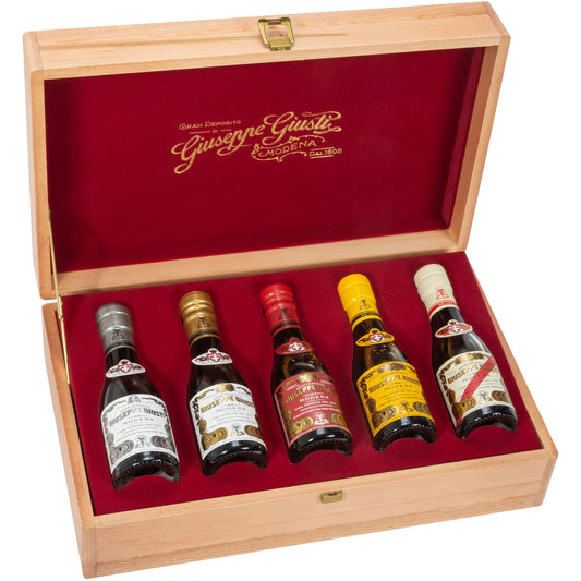 Set of five miniature bottles in a wooden box with red interior, featuring the 'Gianfranco Gusti' brand.