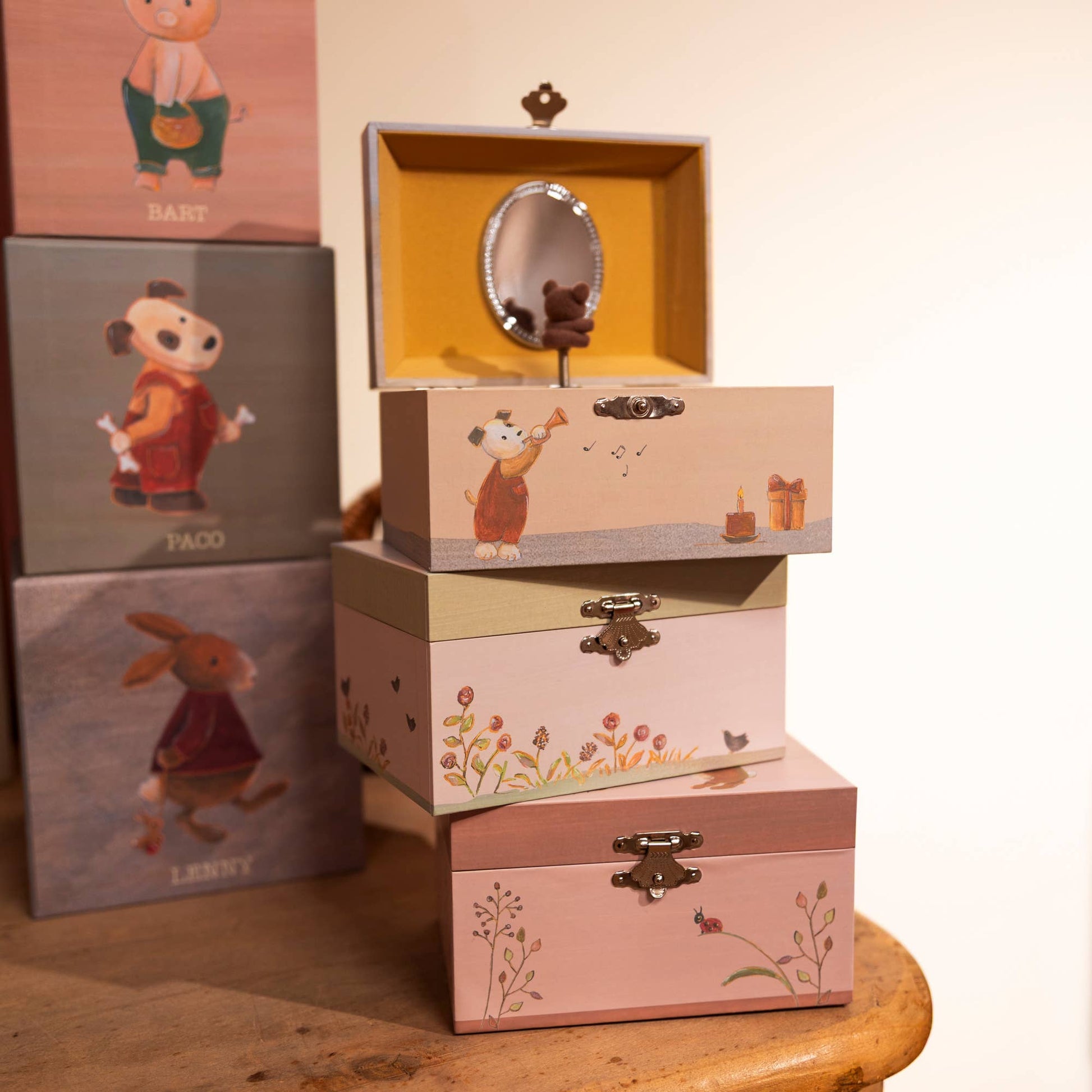 Stack of decorative boxes with animal illustrations on a wooden surface