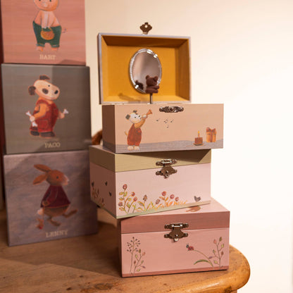Stack of decorative boxes with animal illustrations on a wooden surface