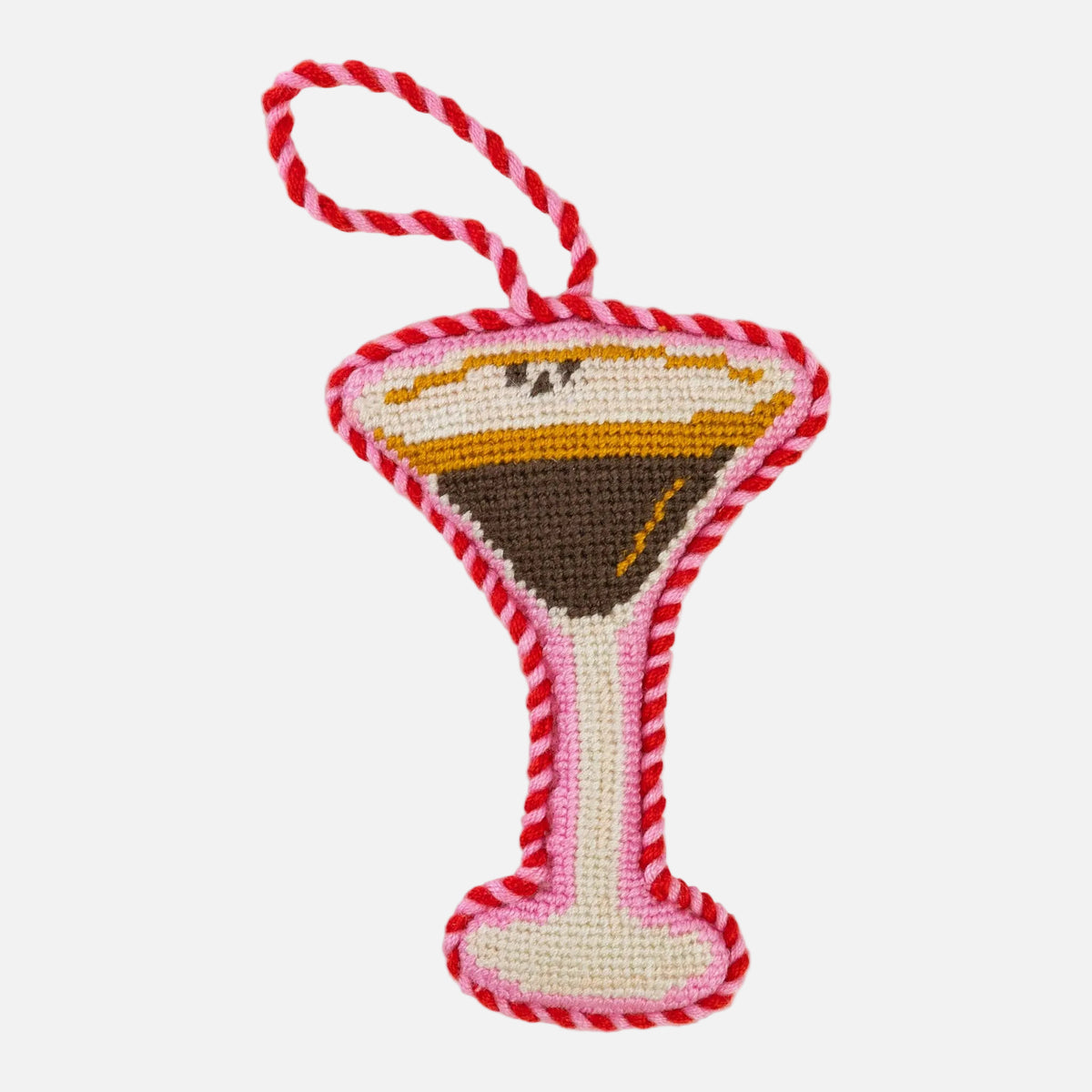 Crocheted martini glass toy with red and white striped handle on a white background