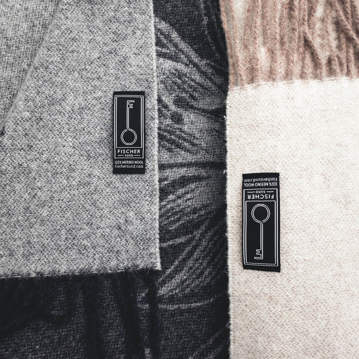 Close-up of a gray and black patterned fabric with a Fischer label, followed by a beige and brown patterned fabric with a Fischer label.