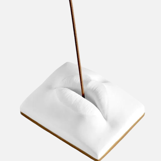 Incense stick in a white ceramic holder on a white background