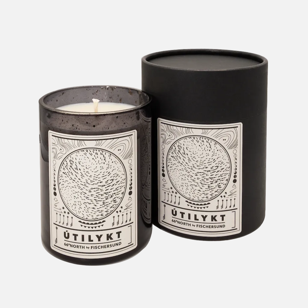 Candle in a black container with 'Ütilykt' branding on a white background