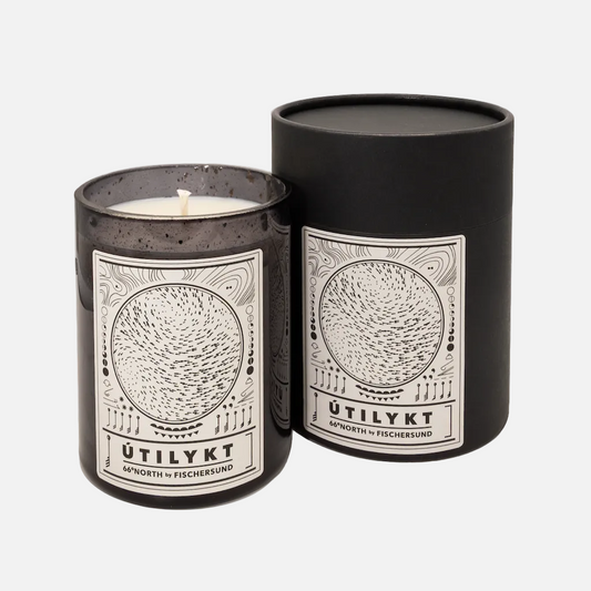 Candle in a black container with 'Ütilykt' branding on a white background